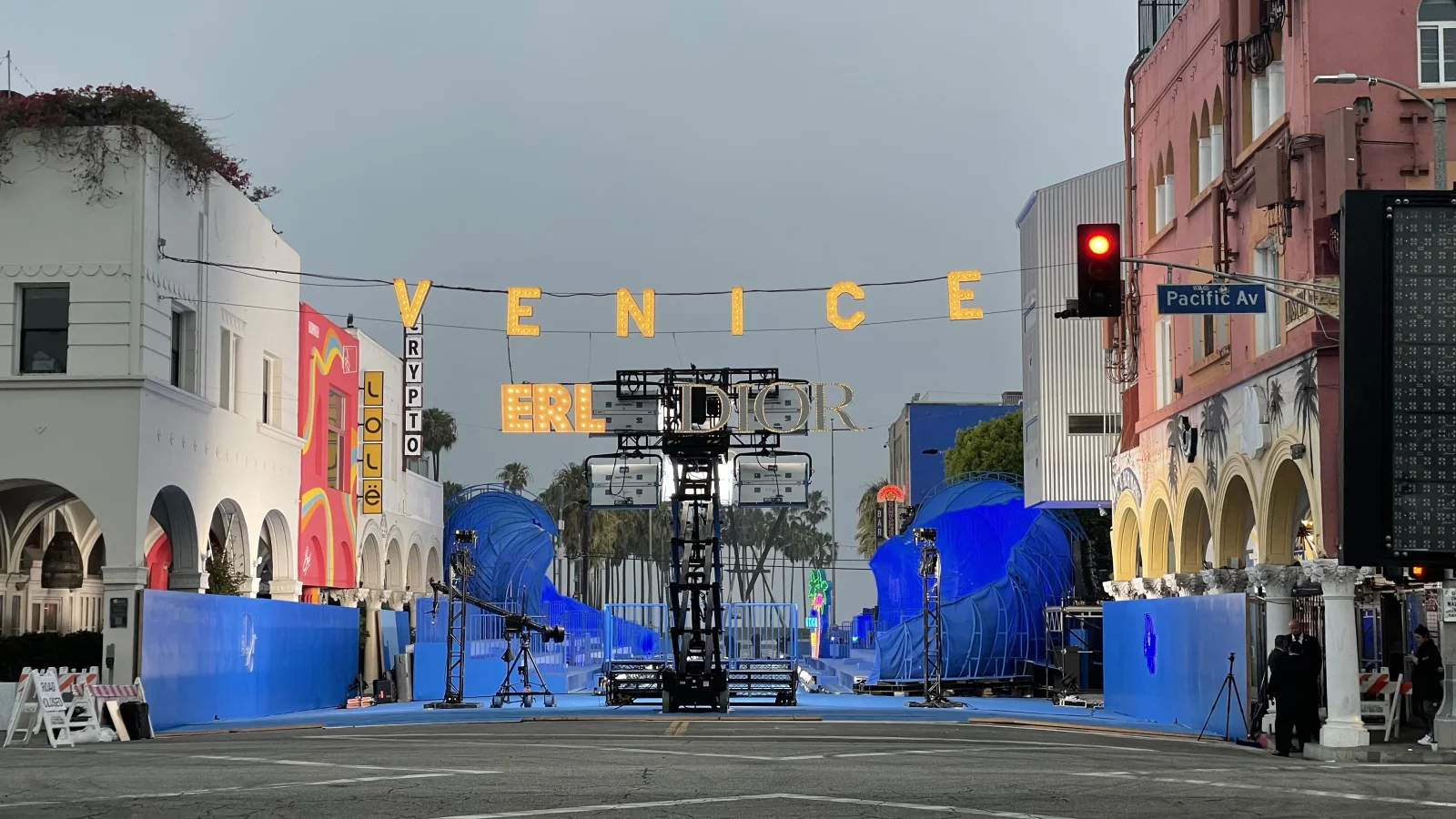 DIOR HOMME — VENICE in gold letters over the street, the blue set built and the light going down