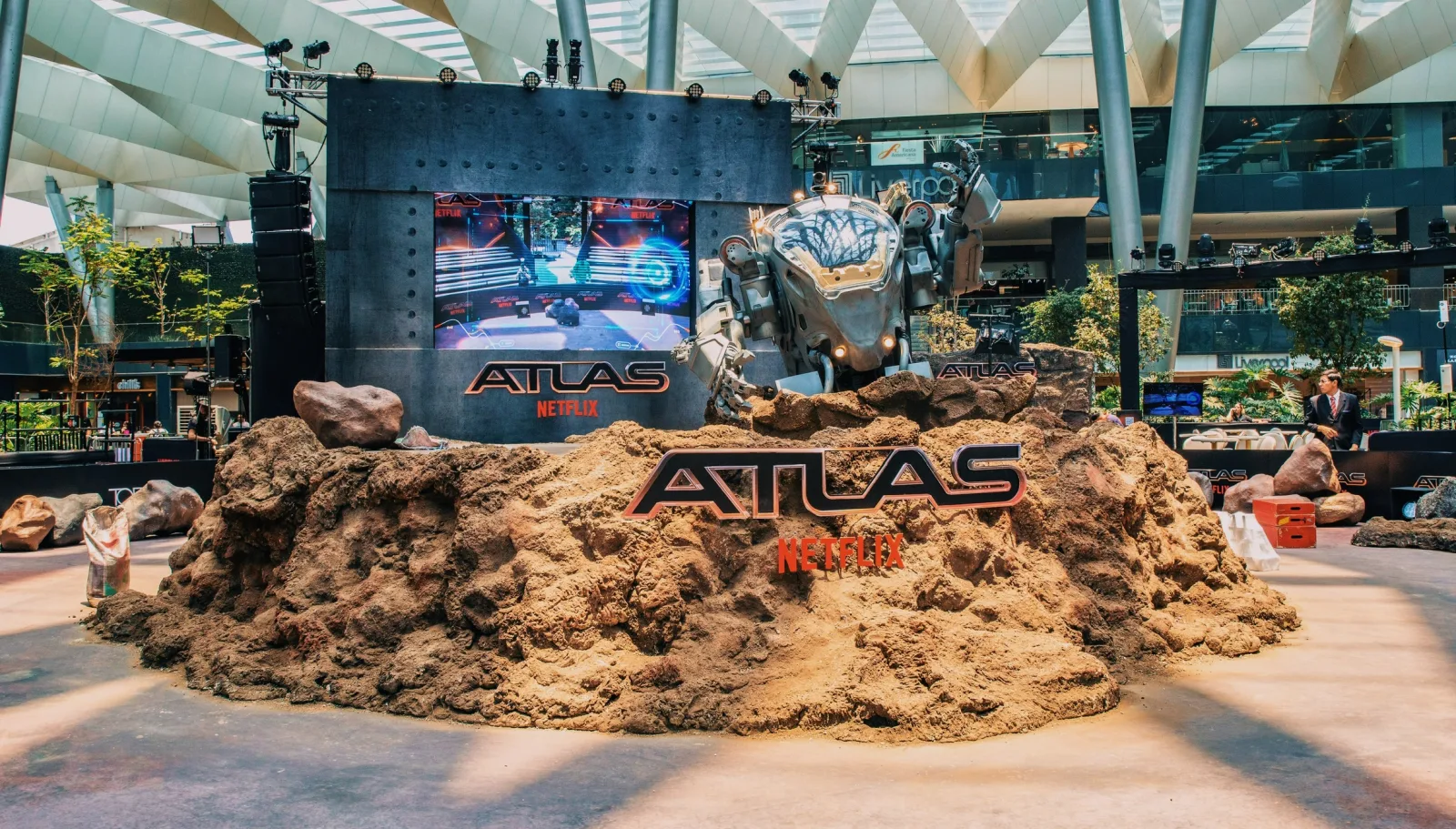 ATLAS — The alien terrain with the mech behind and the ATLAS sign, inside the venue